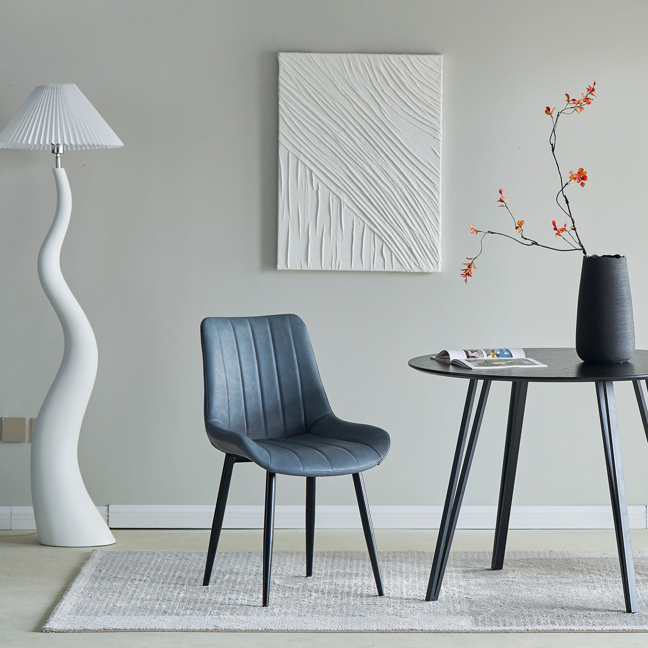 A set of two gray faux leather dining chairs with a modern design and metal legs, displayed in a room setting.