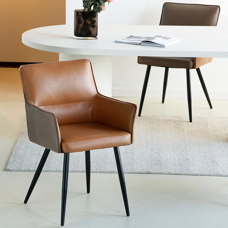 Elevate dining with Kaya’s PU leather armchairs featuring two tone patchwork upholstery, foam padded seat, and black steel legs for a modern, durable finish.