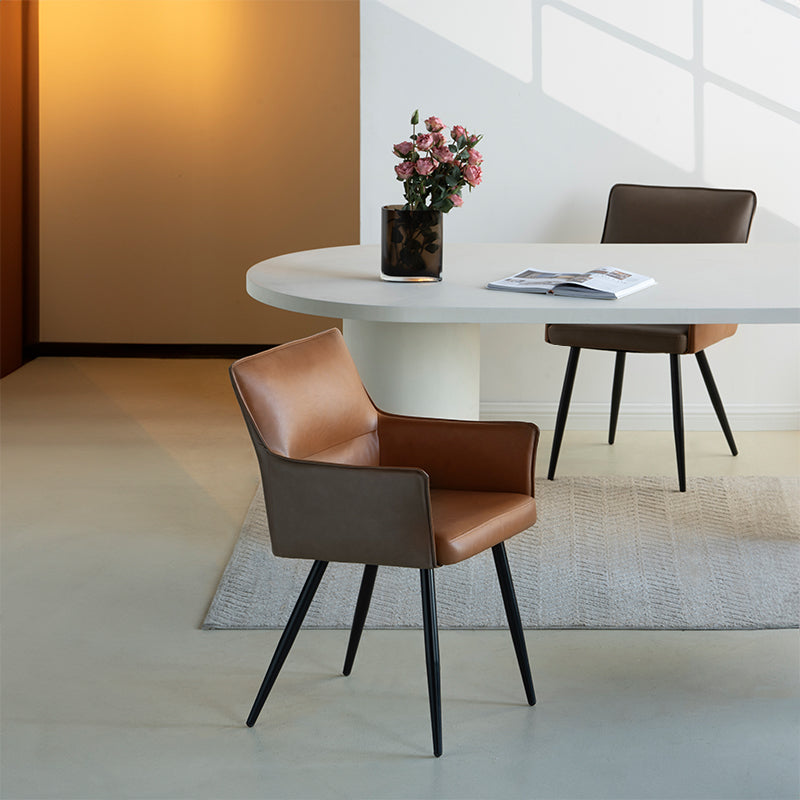 Elevate dining with Kaya’s PU leather armchairs featuring two tone patchwork upholstery, foam padded seat, and black steel legs for a modern, durable finish.