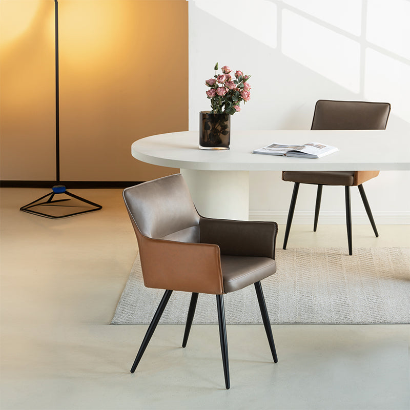 Elevate dining with Kaya’s PU leather armchairs featuring two tone patchwork upholstery, foam padded seat, and black steel legs for a modern, durable finish.