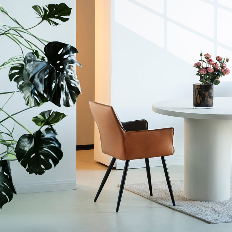 Elevate dining with Kaya’s PU leather armchairs featuring two tone patchwork upholstery, foam padded seat, and black steel legs for a modern, durable finish.