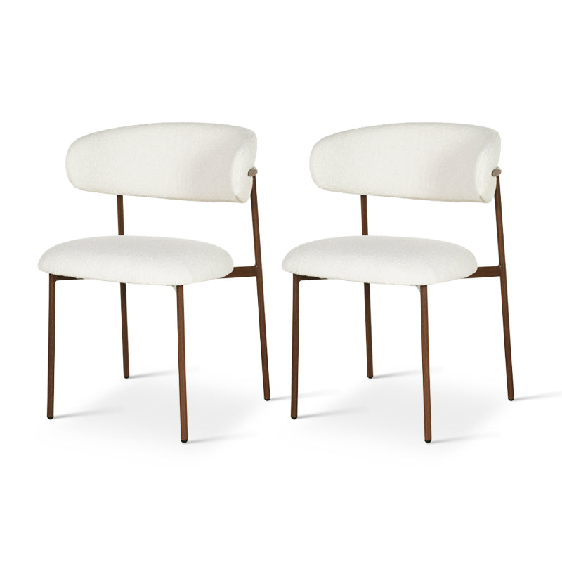 Four white bouclé dining chairs around oval wooden table in modern minimalist interior
