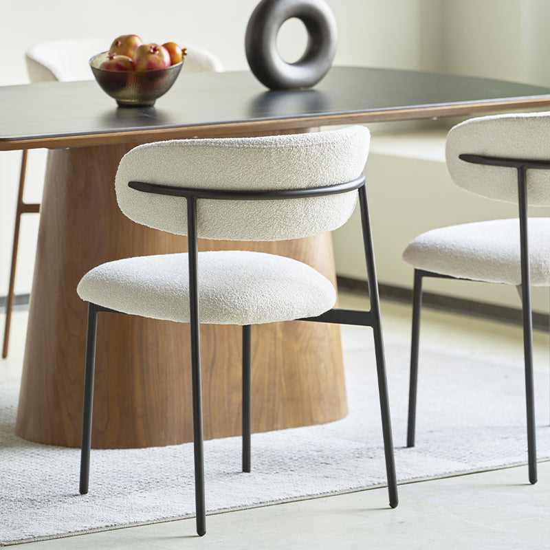 White bouclé fabric dining chair with curved backrest and tapered wooden legs - contemporary kitchen or dining room seating