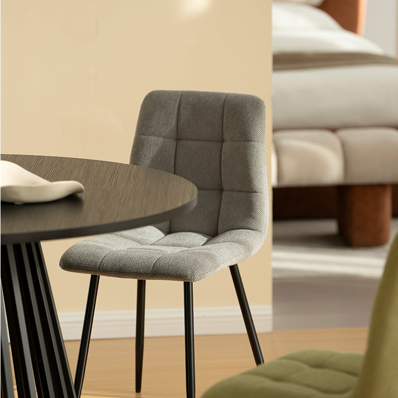 Experience comfort and style with Aoife Dining Chairs: linen blend upholstery, diamond grid stitching and slender metal legs for modern elegance.
