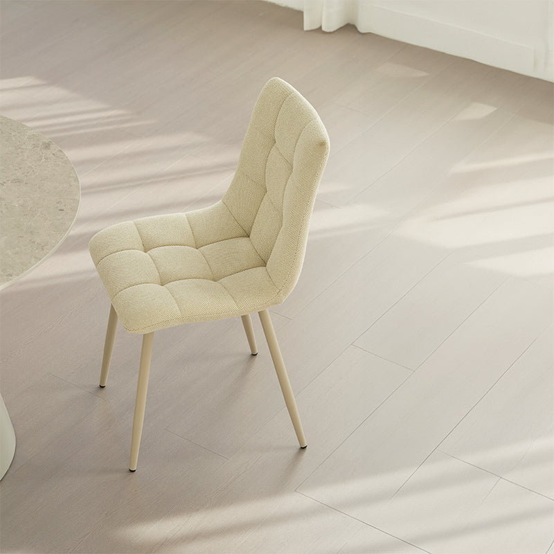 Experience comfort and style with Aoife Dining Chairs: linen blend upholstery, diamond grid stitching and slender metal legs for modern elegance.
